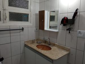 a bathroom with a sink and a mirror at Espaço Acolhedor perto da Praia. in São Vicente +31 photos