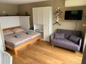 um quarto com uma cama e um sofá em Seehaus Weiss em Rothenthurn