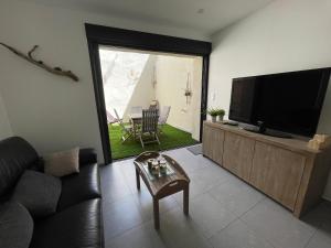 a living room with a tv and a couch and a table at Whalecome Camargue in Aigues-Mortes