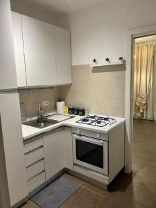 a kitchen with white cabinets and a stove top oven at Casa Digio in Pescara +2 photos