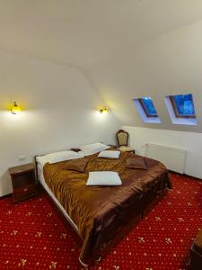 Hotel Bistrita في دوراو: غرفة نوم بسرير كبير في غرفة بها نوافذ