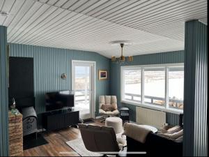a living room with a couch and a tv at Nónhóll - Ocean View Cottage in Arnarstapi in Stapi