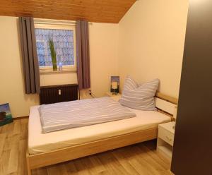 a bed in a small room with a window at Ferienwohnung an den Itzauen in Großheirath