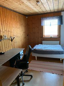een kamer met een bed, een bureau en een stoel bij Barts house in Länshult