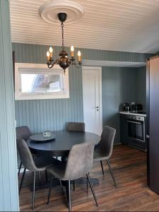 a dining room with a black table and chairs at Nonholl country cottage - Perfect getaway in Arnarstapi