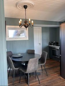 a dining room with a black table and chairs at Nónhóll - Ocean View Cottage in Arnarstapi in Stapi +45 photos