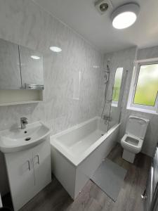 uma casa de banho com um lavatório, uma banheira e um WC. em Lovely 2 Bedroom House em Cheshunt