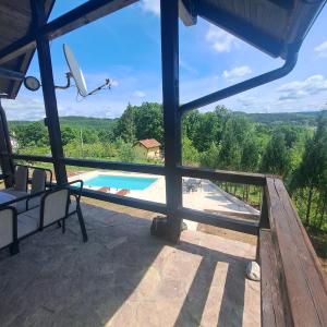 a view from the balcony of a house with a swimming pool at Vikendica Nature park Banja Luka in Banja Luka