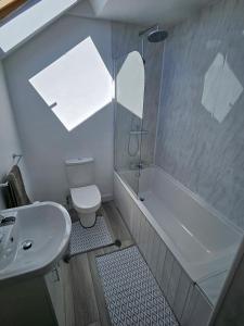 a bathroom with a sink and a tub and a toilet at Four Winds B&B StDavids in St. Davids