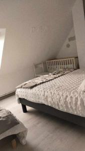 1 dormitorio con 1 cama con edredón blanco en chambre rez de chaussée SDB privée, salon et cuisine partagés, en Ferques