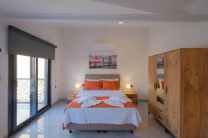 Un dormitorio con una cama grande con almohadas naranjas. en Villa Erika 1, en Fethiye 18 fotos más