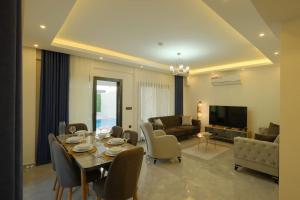 Un comedor y una sala de estar con mesa y sillas. en Villa Erika 1, en Fethiye