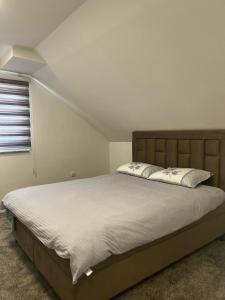 ein Schlafzimmer mit einem großen Bett mit weißer Bettwäsche und einem Fenster in der Unterkunft Vila Sarajlić in Srebrenik