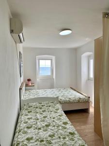 a bedroom with two beds and a window at Milena in Petrovac na Moru