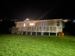 a mobile home on a lawn at night at JSNHolidays@CraigTara in Ayr