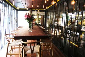 a long table in a restaurant with chairs and a vase of flowers at Le Dream Boutique Hotel in George Town