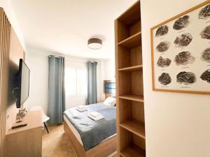 ein Schlafzimmer mit einem Bett und einem Bücherregal in der Unterkunft Sea Apartment 3Bed Small Oasis in Castillo de Sabinillas