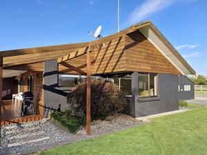 a house with a wooden pergola at Palms on Bruntwood in Tamahere