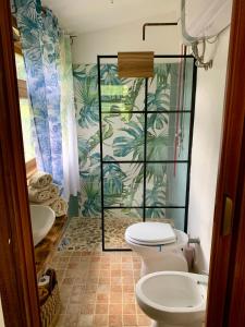 a bathroom with a toilet and a sink with a mural at La stanza di Campagna in Campiglia Marittima