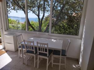 a dining room with a table and chairs and a large window at Summer cottage with breathtaking view in Zečevo
