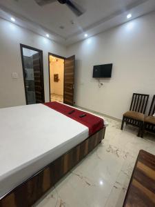 Schlafzimmer mit einem Bett und einem Flachbild-TV in der Unterkunft Embasy Hotel Near Golden Temple in Amritsar