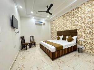 Schlafzimmer mit einem Bett und einem Deckenventilator in der Unterkunft Embasy Hotel Near Golden Temple in Amritsar
