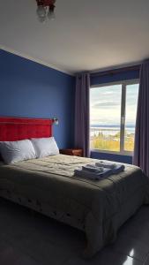 Un dormitorio con una cama grande con una ventana grande. en Virgin Of The Rock, en El Calafate