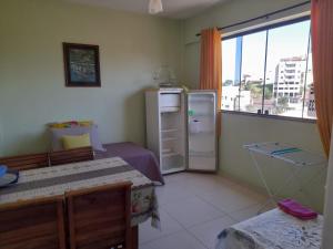 a small room with a refrigerator and a window at Suites e Kitnets praia Iriri in Anchieta