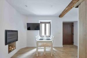 a dining room with a table with chairs and a tv at La casita de Ane - Panticosa in Panticosa