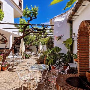 ComaresにあるHotel Rural Verde Olivaの中庭の屋外パティオ(椅子、テーブル付)