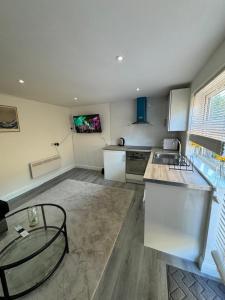 a large kitchen with a table and a tv on the wall at Exclusive Lakeside Apartment in Grays Thurrock
