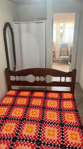 a bedroom with a bed with a patterned blanket on it at Apê do NADINHO in Caparaó Velho