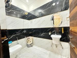 a bathroom with a black and white marble wall at Embasy Hotel Near Golden Temple in Amritsar