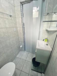 a bathroom with a shower and a toilet and a sink at Quarto privativo no centro 01 in Itapira