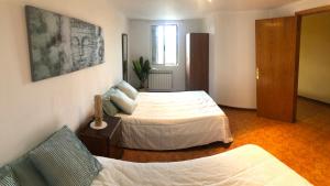um quarto com 2 camas e um sofá em La casita del Bierzo em Carracedelo