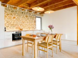 a kitchen with a wooden table and chairs at La Maison de Léon in Saint-Georges-de-Gréhaigne +18 photos