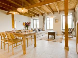 a kitchen and living room with a table and chairs at La Maison de Léon in Saint-Georges-de-Gréhaigne