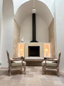 a living room with two chairs and a fireplace at Alora boutique suites in Lecce