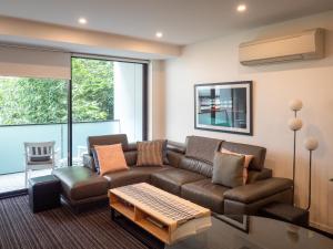 a living room with a couch and a table at Modern Quiet 1 & 2 Bed Apt Opposite Albert Park in Melbourne