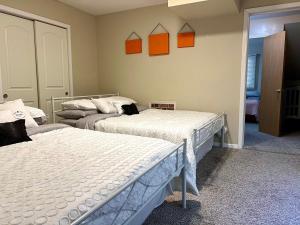 two beds in a room with orange pictures on the wall at Couture Themed 3 Bedroom in Prime Spot with Patio, Parking, Fireplace, Pets Welcome in Chicago