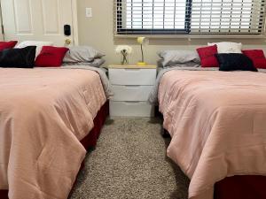 Duas camas sentadas uma ao lado da outra num quarto em Couture Themed 3 Bedroom in Prime Spot with Patio, Parking, Fireplace, Pets Welcome em Chicago