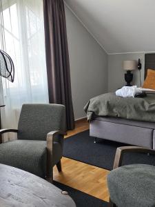 Hotel Skansen في فارجيستادين: غرفة معيشة مع سرير وكرسي