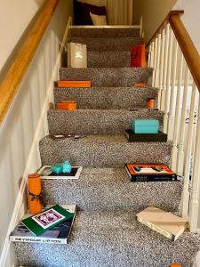 a stair case with books and boxes on it at Couture Themed 3 Bedroom in Prime Spot with Patio, Parking, Fireplace, Pets Welcome in Chicago