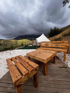 deux bancs en bois assis au-dessus d'une terrasse en bois dans l'établissement Glamping Finca el Olivo, à Mijas