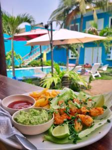 um prato de comida com camarão e guacamole numa mesa em Hotel el Paredon em El Paredón Buena Vista