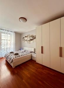 una camera con un grande letto e armadi bianchi di Blu Trieste a Trieste