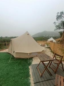 une tente, une table de pique-nique et un banc dans l'établissement Glamping Finca el Olivo, à Mijas
