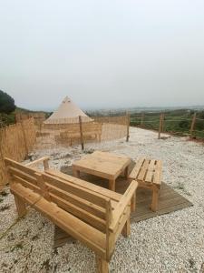a picnic table and a tent in a field at Glamping Finca el Olivo in Mijas