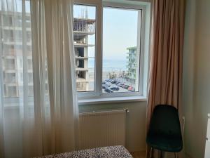 a bedroom with a window with a view of a city at Nord Residence in Mamaia Nord
