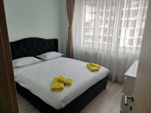 a bedroom with a bed with yellow towels on it at Nord Residence in Mamaia Nord